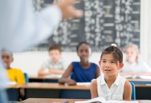 photo of young students sitting at desks in a classroom