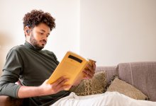 Photo of man reading book at home